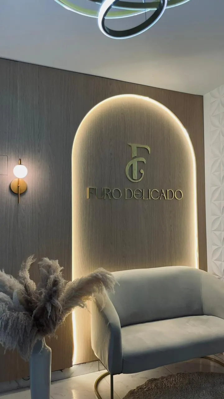Recepção do Furo Delicado, com o logo iluminado em um painel em arco